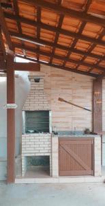 eine Außenküche mit Backofen in einem Gebäude in der Unterkunft Linda Casa Com Vista Para a Praia! in São Pedro da Aldeia