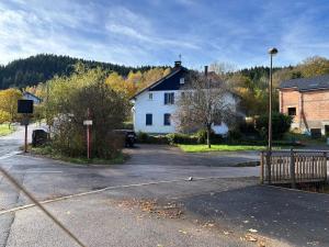 a white house sitting in the middle of a street at Les Coteaux in Gérardmer