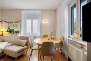 un salon avec une table, des chaises et un canapé dans l'établissement City Spa Haus Lörrach, à Lörrach