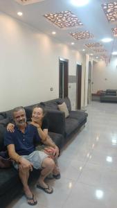 un hombre y una mujer sentados en un sofá en Gannet Alyousef City Center, en Naj‘ al Maḩaţţah