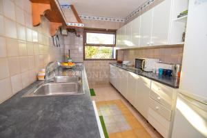 eine kleine Küche mit Spüle und Fenster in der Unterkunft Punta Llarga in Colònia de Sant Pere
