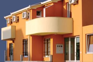 un edificio arancione con balcone di Pansion Boris a Međugorje