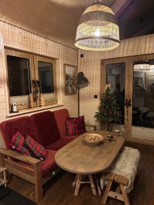 a living room with a couch and a table with a christmas tree at Hygge z kominkiem i sauna Piasek Cedynia Chojna in Piasek