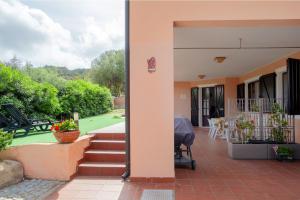 een huis met een patio en een tuin met stoelen bij Mira Holiday Apartment - Chia CIN IT11101CR in Chia