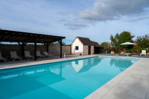 a swimming pool with chairs and a house at Maison 2 in Souvigny