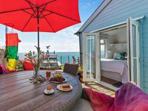 d'une terrasse avec une table et un parasol rouge. dans l'établissement 1 Bed in Whitsand Bay 74824, à Millbrook