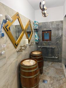 zwei Holzfässer in einem Badezimmer mit Waschbecken in der Unterkunft Carul cu Flori in Craiova
