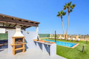 a backyard with a fireplace and a swimming pool at Villa Humaik by Villa Plus in Antigua