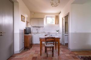 eine Küche mit Tisch und Stühlen in einem Zimmer in der Unterkunft Gemütliches Appartement in Pesaro mit Garten, Grill und gemeinsamem Pool in Pesaro