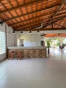 una grande sala aperta con tavoli e un bar di Sítio Carmo a Ibirité