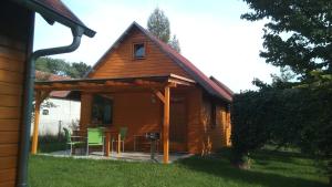 a wooden cabin with a deck with a table and chairs at Ferienwohnungen Goller in Großkoschen