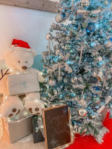 a teddy bear sitting next to a christmas tree at Best Western Hotel Mediterranee Menton in Menton