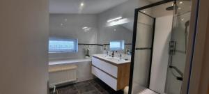 a bathroom with a sink and a large mirror at Maison confortable 6 personnes - 3 chambres - Espaces partagés in Saint-Sauvant