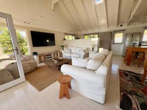 克尼斯纳Lagoonside Lookout的配有白色家具和平板电视的客厅