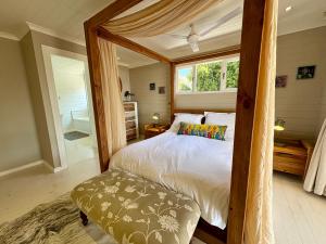 克尼斯纳Lagoonside Lookout的一间卧室设有天蓬床和窗户。