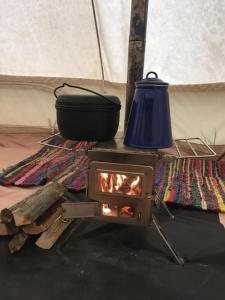 - une cuisinière avec un pot et une cuisinière dans l'établissement Zeltferien Into The Wäid Zelt Unter Der Esche, à Ennetmoos