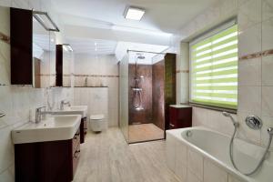 a bathroom with two sinks and a tub and a shower at Geräumige Ferienvilla Jenny Am Strand Mit Pool in Klütz