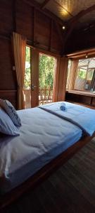 a large bed in a room with a window at Kubu Nadhi in Ketewel