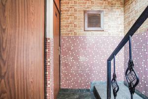 a staircase with a tile wall and a window at Hotel O by OYO Exotica Palace in New Delhi