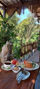 a wooden table with plates of food on it at Kubu Nadhi in Ketewel