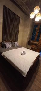a bedroom with a bed with two towels on it at Kubu Nadhi in Ketewel +21 photos