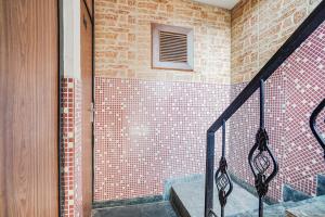 a staircase in a house with a brick wall at Hotel O by OYO Exotica Palace in New Delhi