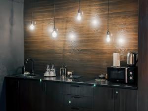 a kitchen with a counter with a microwave and lights at Люкс в стиле LOFT in Pavlodar