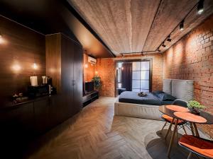 a bedroom with a bed and a brick wall at Люкс в стиле LOFT in Pavlodar