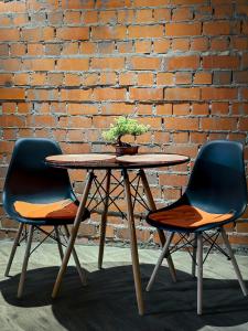 two chairs and a table in front of a brick wall at Люкс в стиле LOFT in Pavlodar