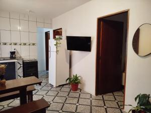 una cucina con frigorifero, tavolo e porta di Sunset Flats - Flat de 2 quartos bem perto das praias e na rua Pituba 1 a Itacaré