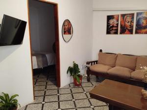 un soggiorno con un divano e uno specchio di Sunset Flats - Flat de 2 quartos bem perto das praias e na rua Pituba 1 a Itacaré