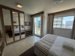 ein Hotelzimmer mit einem Bett und einem großen Fenster in der Unterkunft Saint Moritz Hotel - ALM hospedagens - Flat Particular 2 in Brasilia