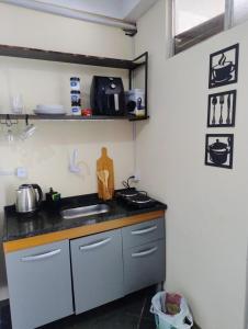 eine Küche mit Spüle und Arbeitsplatte in der Unterkunft Loft em rua de comércio em condomínio in Curitiba