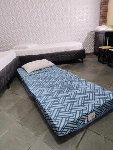 2 Betten auf dem Boden in einem Zimmer in der Unterkunft Loft em rua de comércio em condomínio in Curitiba