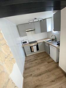 Il comprend une cuisine avec des placards blancs et du parquet. dans l'établissement Charmante maison atypique ambiance ville village, à Deuil-la-Barre