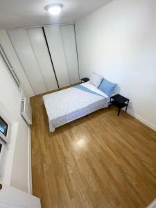 - une petite chambre avec un lit et du parquet dans l'établissement Charmante maison atypique ambiance ville village, à Deuil-la-Barre