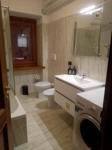 ein Badezimmer mit Waschbecken und Waschmaschine in der Unterkunft Dolomiti Apartment in Domegge di Cadore + 24 Fotos