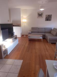 ein Wohnzimmer mit Sofa und Tisch in der Unterkunft Dolomiti Apartment in Domegge di Cadore