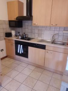 eine Küche mit Spüle und Herd in der Unterkunft Dolomiti Apartment in Domegge di Cadore