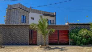 a house with a palm tree in front of a garage at la Villa WOOR Saly Joseph in Mbour