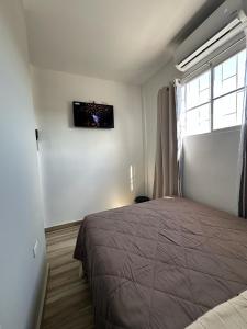 ein Schlafzimmer mit einem Bett und einem TV an der Wand in der Unterkunft Apartamento C Fuertevali in San Salvador