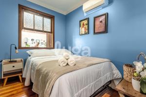 a blue bedroom with a bed with two teddy bears on it at Vieira Eco Inn – Standard Suite in Orleans