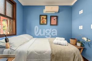 ein Schlafzimmer mit einer blauen Wand und einem Bett in der Unterkunft Vieira Eco Pousada #1 in Orleans