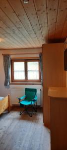 Una habitación con una silla verde en una habitación en Selbstversorgerhütte N 15 Kleinwalsertal, en Hirschegg