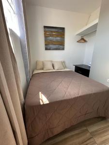 ein Schlafzimmer mit einem Bett in einem Zimmer mit einem Fenster in der Unterkunft Apartamento C Fuertevali in San Salvador