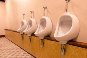 a row of four urinals in a bathroom at Grace Hostel - Chiang Rai in Chiang Rai +31 photos