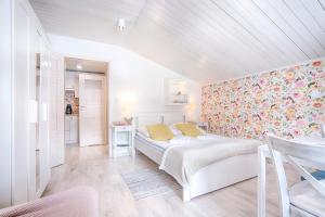 a bedroom with a white bed and a floral wall at Pod Wodospadem in Szczyrk