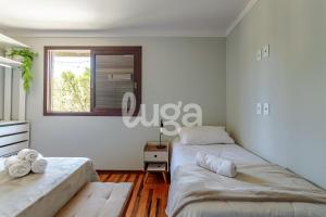 zwei Betten in einem Zimmer mit Fenster in der Unterkunft Vieira Eco Pousada #2 in Orleans