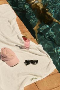 ein Hut und eine Sonnenbrille neben einem Swimmingpool in der Unterkunft Scavolo Borgo in SantʼAgata Feltria