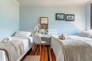 a bedroom with two beds and a desk in it at Vieira Eco Inn – Deluxe Suite Vanio #2 in Orleans
